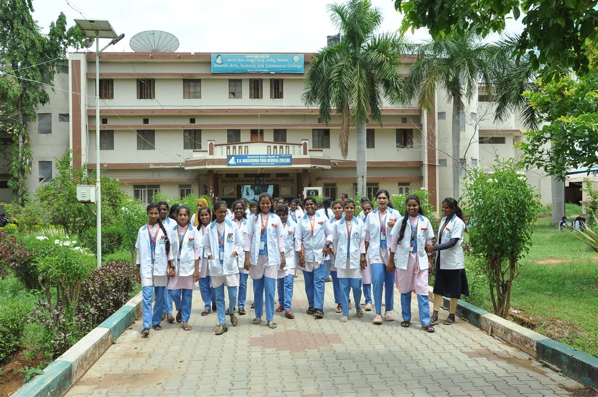 College students in white coats outside the campus building